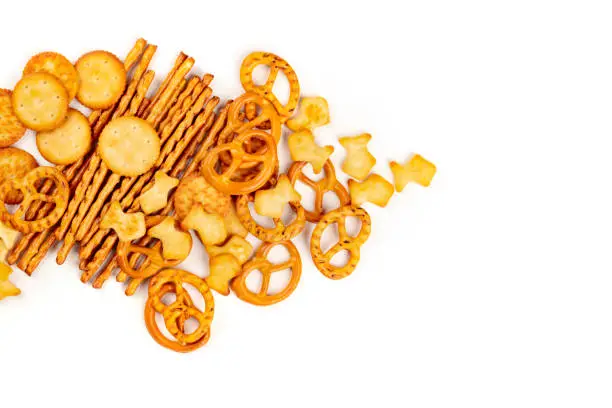 Photo of A photo of an assortment of salt crackers, sticks, pretzels, and fishes, shot from the top on a white background with copy space