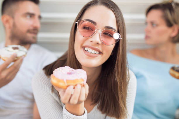 istock Beautiful young woman eating donut 1061697340