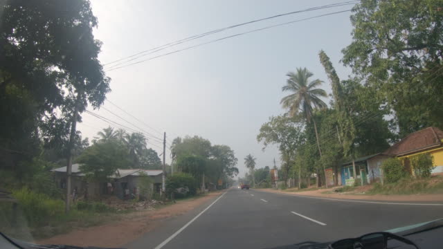 MS Car driving along sunny road,using windshield wipers,Sri Lanka