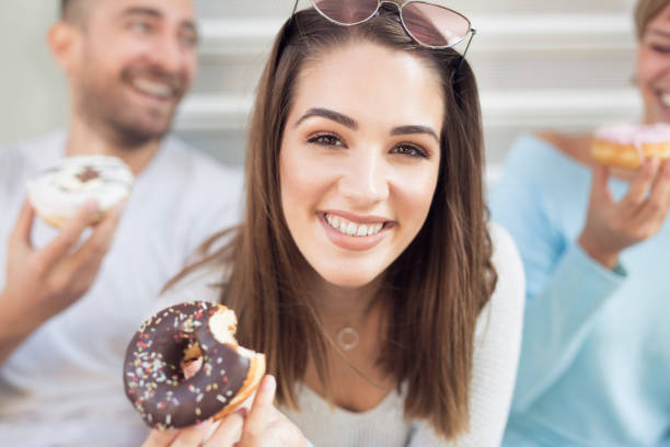 istock Beautiful young woman eating donut 1061700114