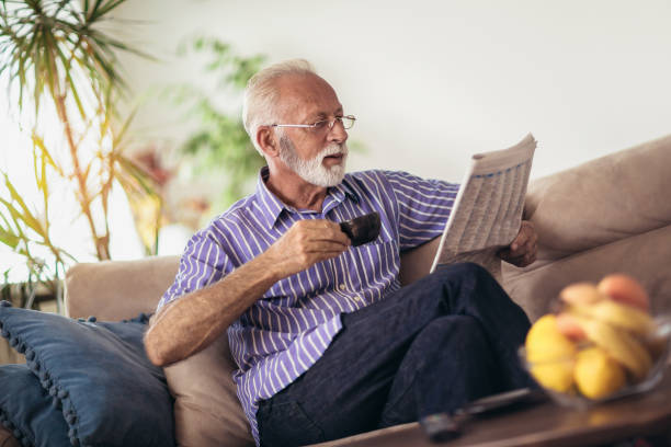 수석 남자 집에서 독서 신문 - mature adult home interior chair contemporary 뉴스 사진 이미지