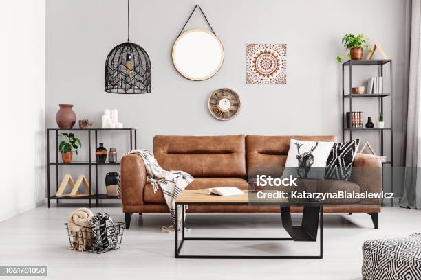 Leather Sofa With Pillows And Blanket In The Middle Of Elegant Living Room Interior With Metal Shelves And Modern Coffee Table Real Photo Stock Photo - Download Image Now
