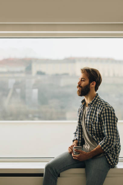istock Serious man relaxing by the window during his coffee time. 1061707268