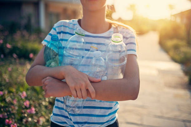 Teenage girl carried sorted garbage plastic bottles. Girl is going to putting plastic bottles into plastic container.Nikon D850
