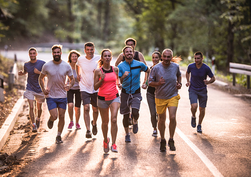 Large group of athletic people running a marathon on the road.