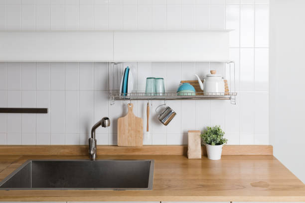 istock Clean dishes drying on metal dish rack on light background. Kitchen utensils and dishware on wooden shelf. Kitchen interior background.Text space. 1061716616