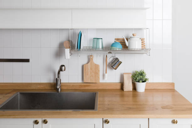 istock Clean dishes drying on metal dish rack on light background. Kitchen utensils and dishware on wooden shelf. Kitchen interior background.Text space. 1061716704