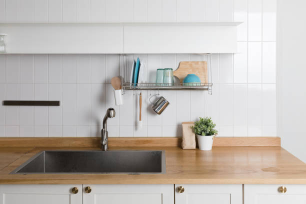 istock Clean dishes drying on metal dish rack on light background. Kitchen utensils and dishware on wooden shelf. Kitchen interior background.Text space. 1061716898