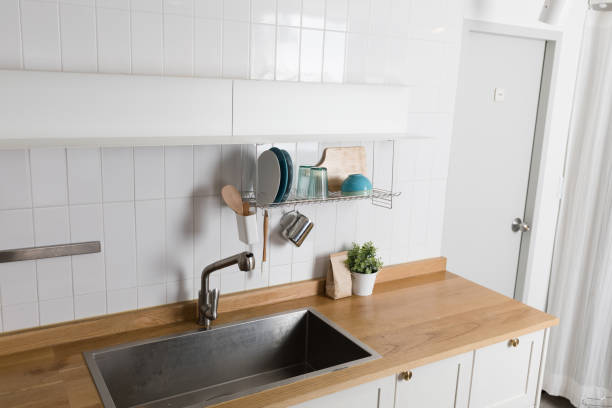 istock Clean dishes drying on metal dish rack on light background. Kitchen utensils and dishware on wooden shelf. Kitchen interior background.Text space. 1061716900
