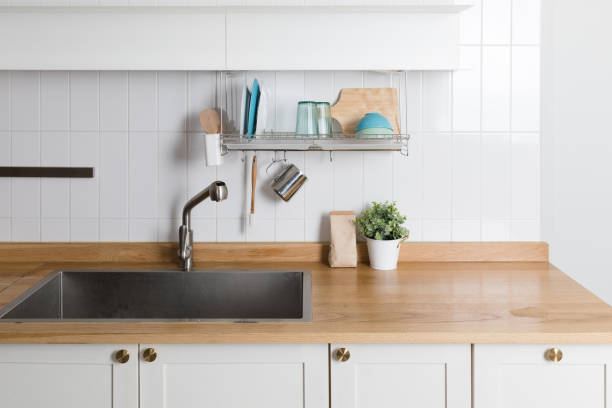 istock Clean dishes drying on metal dish rack on light background. Kitchen utensils and dishware on wooden shelf. Kitchen interior background.Text space. 1061717340