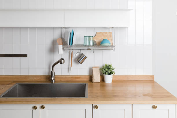 istock Clean dishes drying on metal dish rack on light background. Kitchen utensils and dishware on wooden shelf. Kitchen interior background.Text space. 1061717342