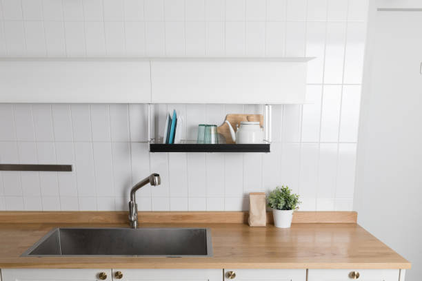 istock Clean dishes drying on metal dish rack on light background. Kitchen utensils and dishware on wooden shelf. Kitchen interior background.Text space. 1061718672