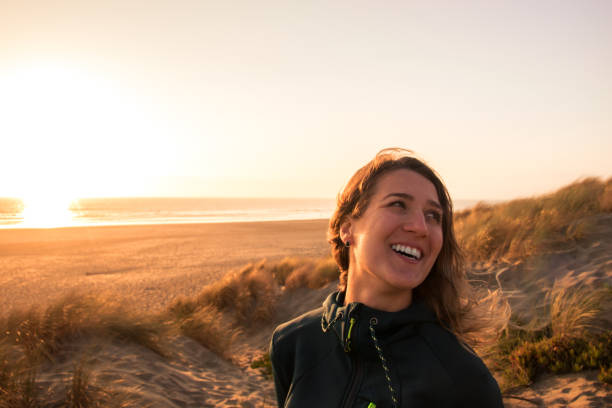 istock Woman smiling at sunset on the beach 1061722580
