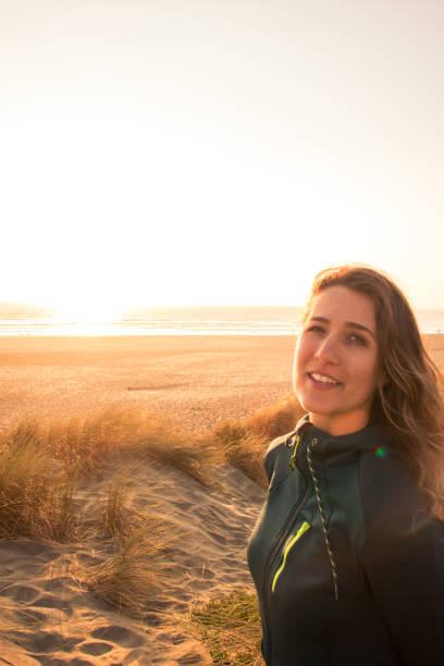 istock Woman smiling at sunset on the beach 1061722624