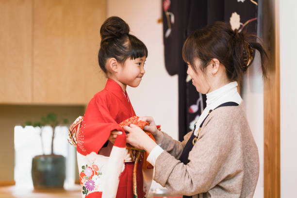 Mother helps her daughter wearing Kimono