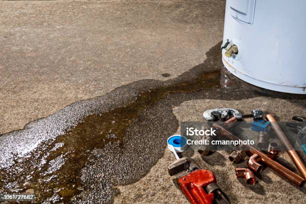 A Leaking Faucet On A Domestic Water Heater With Tools And Fittings To Replace Appliance Stock Photo - Download Image Now