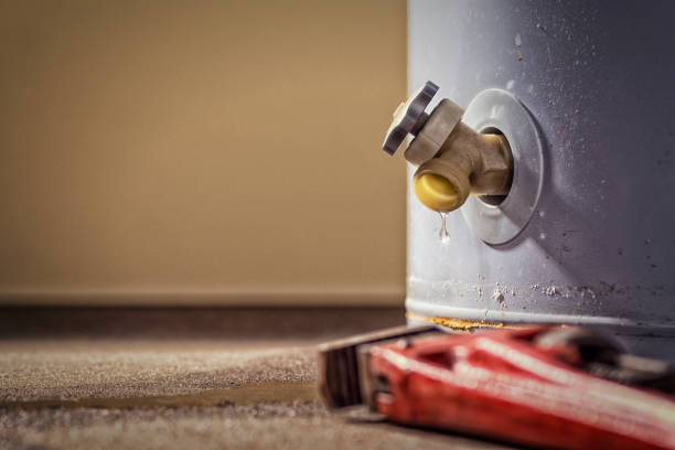 uma torneira vaza em um aquecedor de água para uso doméstico com alicate - water heater boiler water pipe basement - fotografias e filmes do acervo