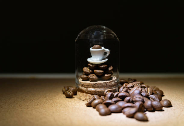 Cup of coffee on coffee bean in glass tube isolated from black background stock photo