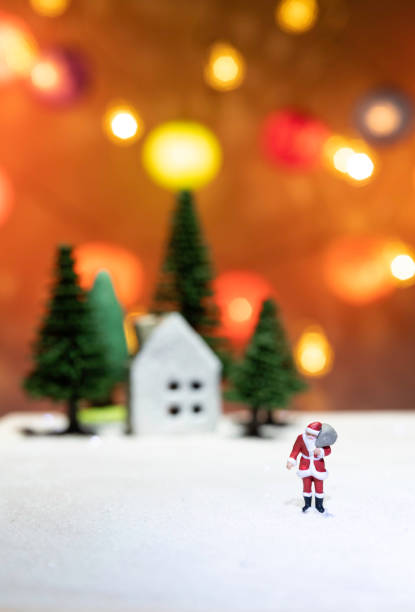 Walking Santa Claus on ice far from house and tree isolated from Christmas light background stock photo