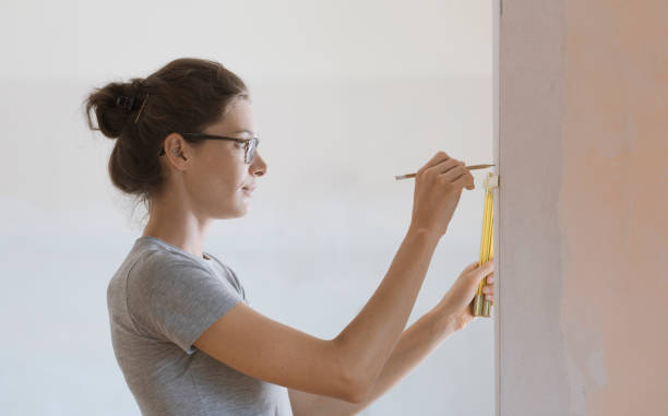 istock Woman doing a home renovation and measuring walls with a ruler 1061733748