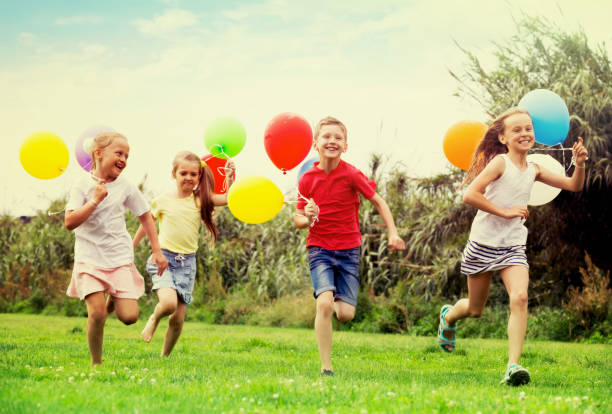 istock children running with air balloons in park 1061742214