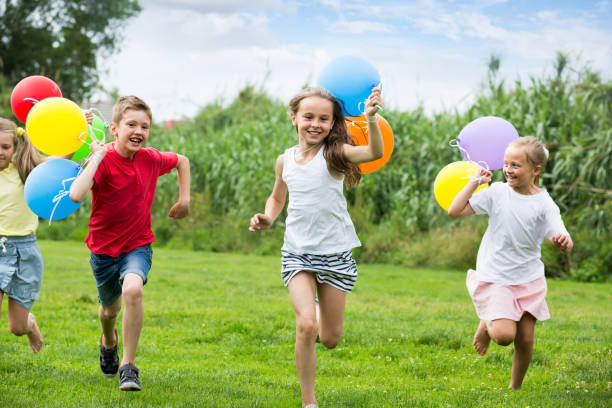 istock children running with air balloons in park 1061742252