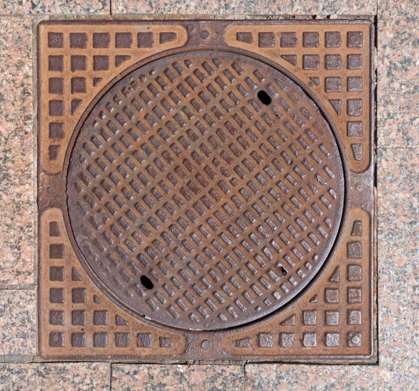istock Old rusty sewer hatch on an old metal plate. View from above. 1061742400