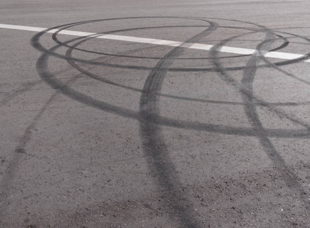 istock Black trail from rubber tires on the asphalt 1061742440