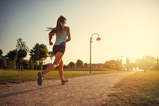 teenager-mädchen joggen im stadtpark - shorts clothing sport sports clothing stock-fotos und bilder