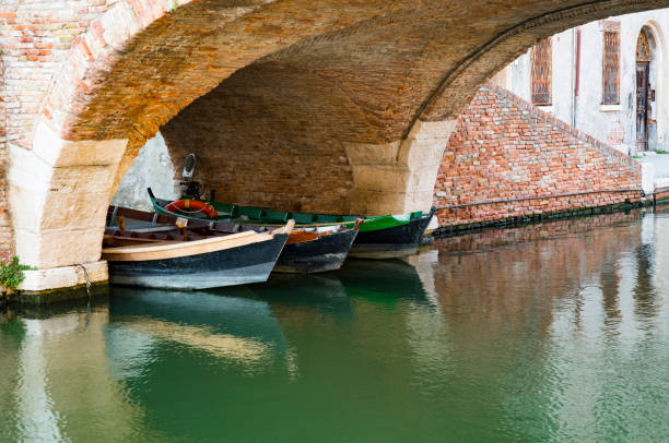 istock boats under bridge in Comacchio, Italy 1061745592
