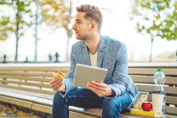 istock Young man is having lunch outdoors 1061749744