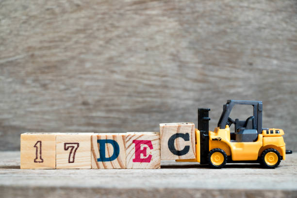 istock Toy forklift hold block c to complete word 17dec on wood background (Concept for calendar date 17 in month December) 1061752074