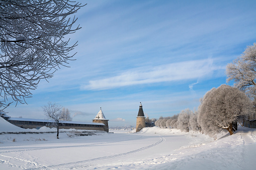 Winter view of medieval Kremlin towers across frozen river in Pskov, Russia, The towers are not museum
