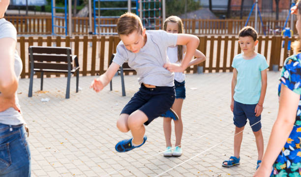 istock Happy children skipping on jumping elastic rope 1061766094