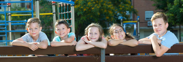 istock Five glad children sitting on a bench 1061766154