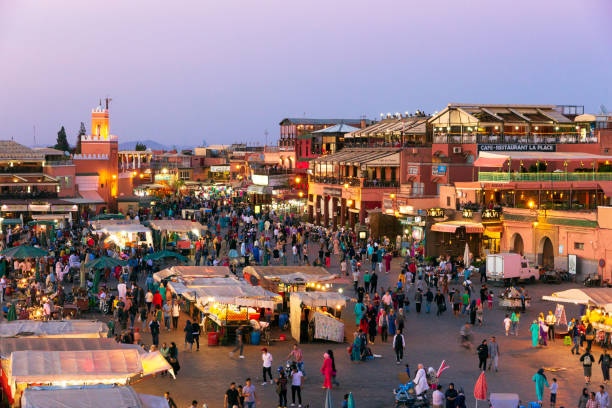 Marrakesh Djemaa El Fna square Marrakesh, Morocco - Apr 27, 2016: Tourists and locals on the Djemaa-el-Fna square during sunset in Marrakesh. djemma el fna square stock pictures, royalty-free photos & images