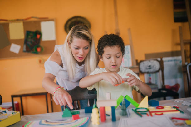 istock Teacher looking at the boy playing with blocks 1061771548