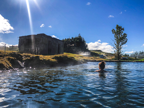 Mujer de una persona nadando en la piscina geotermal en fludir secreto Laguna Islandia photo