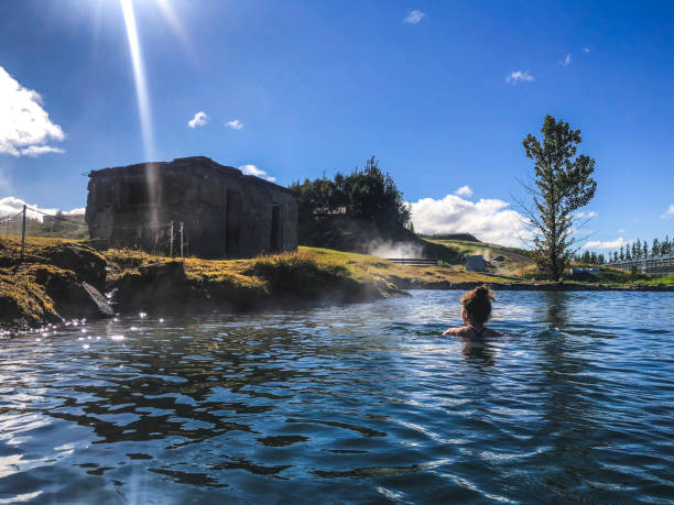 One person woman swimming in geothermal pool in fludir secret lagoon Iceland woman swimming in geothermal water lagoon stock pictures, royalty-free photos & images