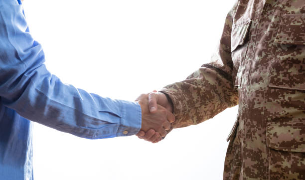 Military and civilian shaking hands standing on white background Military person and civilian shaking hands standing on white background civilian stock pictures, royalty-free photos & images