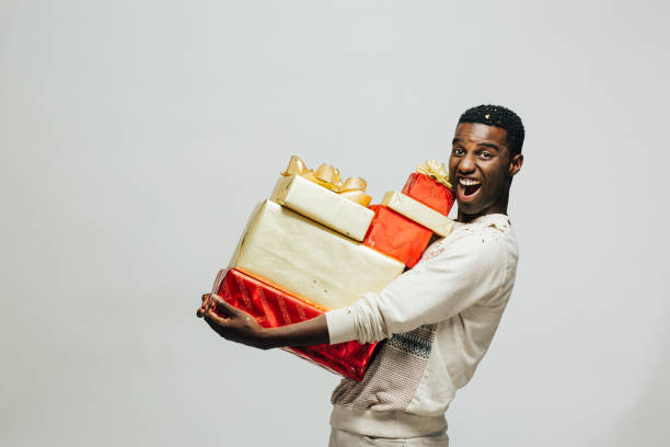retrato de un joven excitado llevar muchos regalos - box men holding isolated fotografías e imágenes de stock