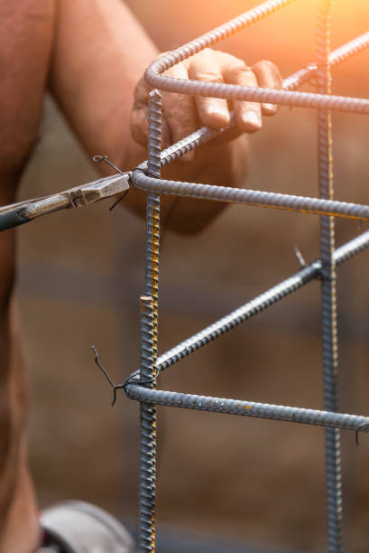 istock Worker Securing Steel Rebar Framing With Wire Plier Cutter Tool At Construction Site 1061803300