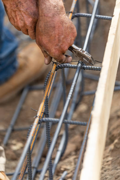 istock Worker Securing Steel Rebar Framing With Wire Plier Cutter Tool At Construction Site 1061803856
