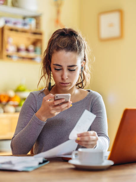 istock Young woman paying bills on computer in kitchen 1061810298