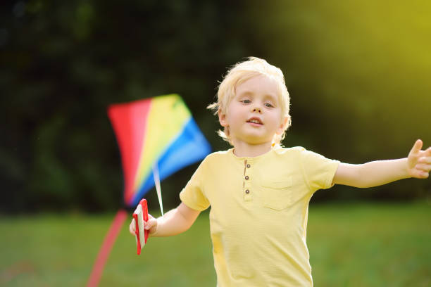 istock Little boy on a sunny day launches a flying kite. 1061811832