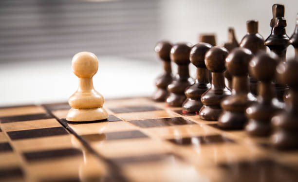 istock One pawn staying against full set of chess pieces.. 1061815680
