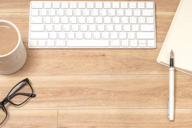 istock Wood office desk table with laptop, glasses, notebook, pen. Top view, copy space. 1061816008