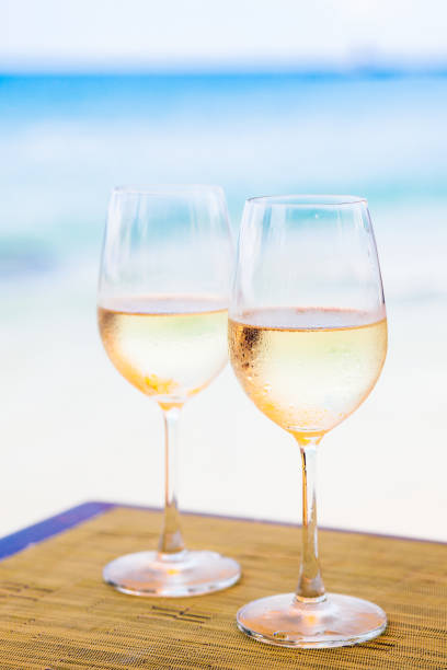 istock two glasses of white wine at beach 1061819650