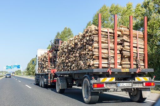 Sopron, Hungary - August 30, 2017: Large truck with timber on the highway. Trailer with firewood