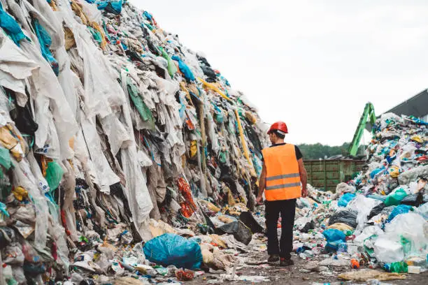 A worker walking between the heaps of garbage